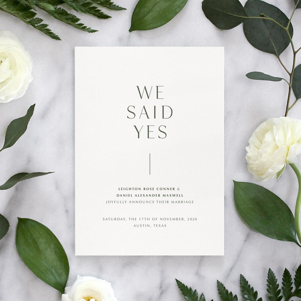 simple 'we said yes' wedding announcement on floral and marble background