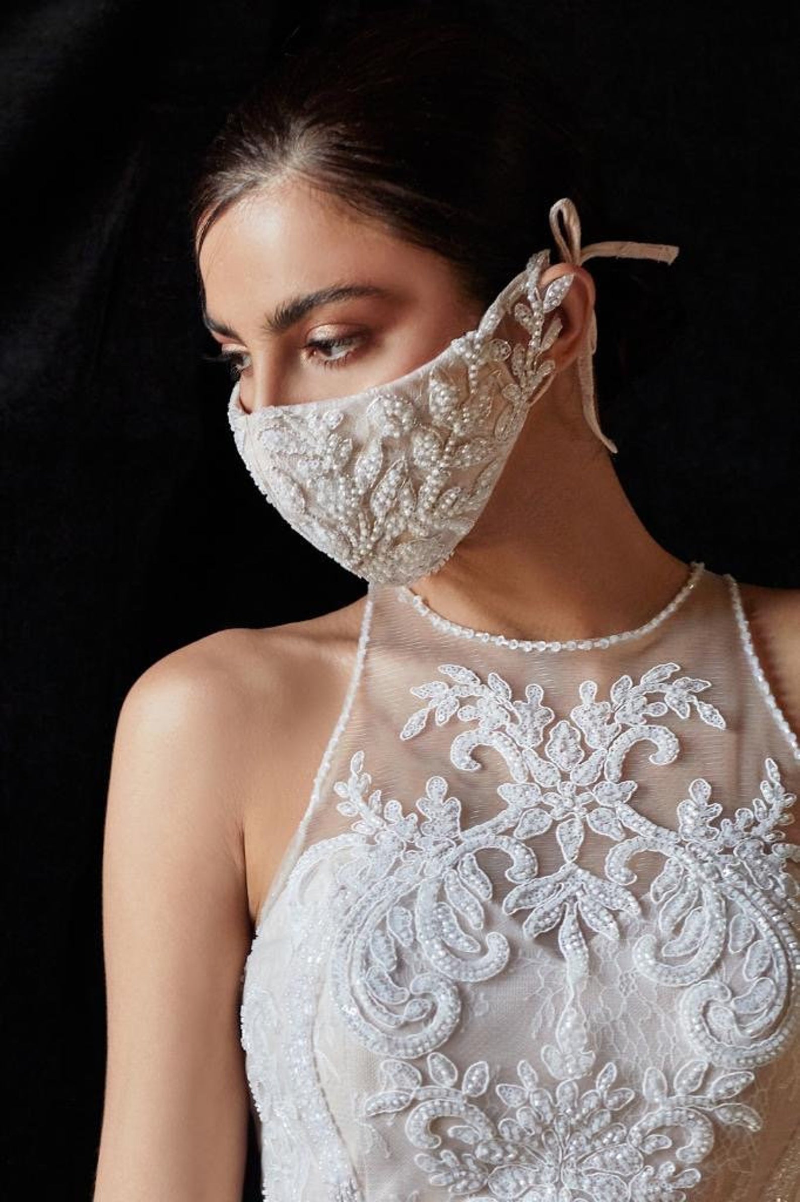 woman in a wedding gown wearing a matching beaded face mask