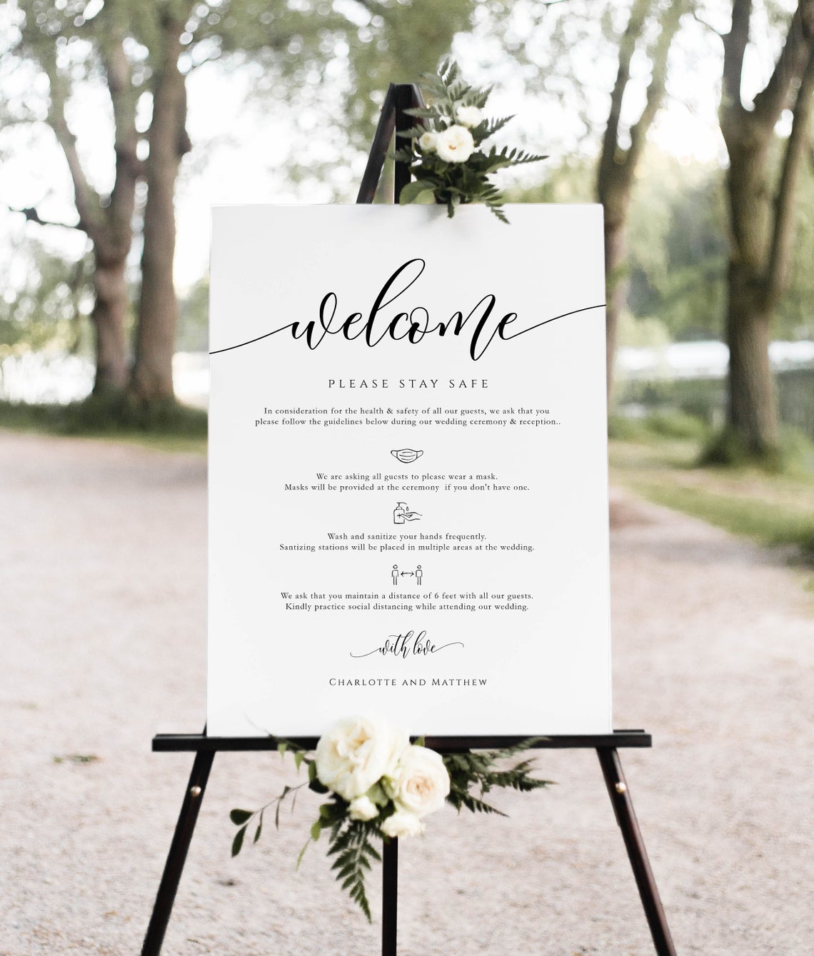 wedding welcome sign on a black stand with flowers