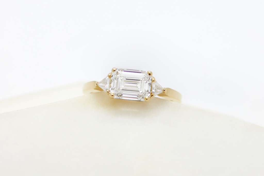 Close up photo of gold and square diamond engagement ring