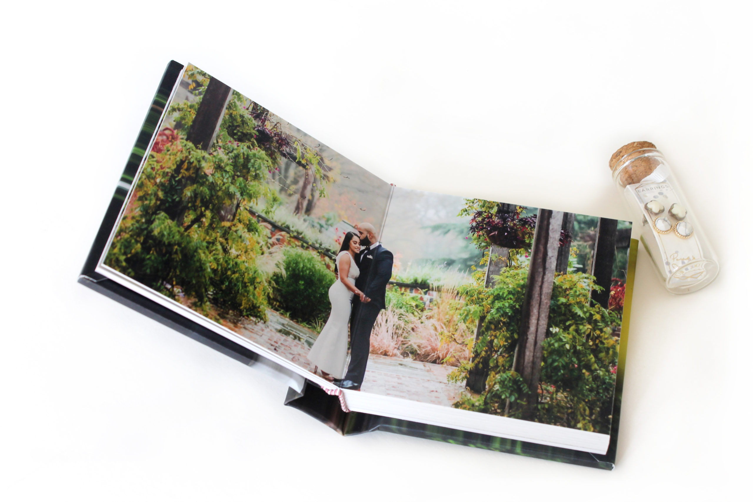 Close-up of Albums Remembered Little Hugs album with a wedding couple kissing in a garden