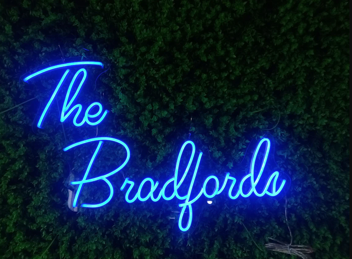 blue neon sign that reads "The Bradfords"